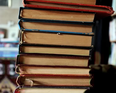 Stapel boeken staan symbool voor de kennis en literatuur die moreel leiderschap in het onderwijs.