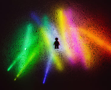 Contour van een persoon met kleurrijke lichtbundels, symboliseert botsende waarden en perspectieven.