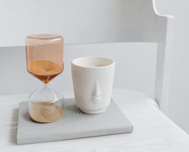 Zandloper op open boek met kop koffie, beeld van tijdsdruk en reflectie bij morele dilemma’s.