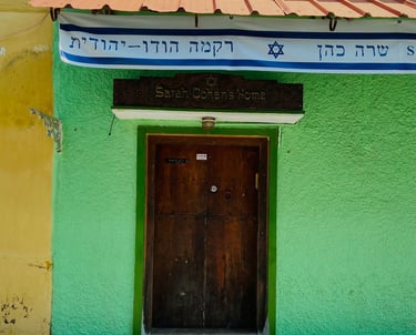 A green and yellow building with a door at Jew Street, Mattancherry Ernakulam 