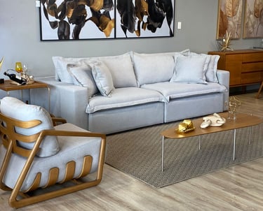 Sala de TV ou sala de estar com mesa de centro, tapete, quadros, estofado, poltrona e decoração
