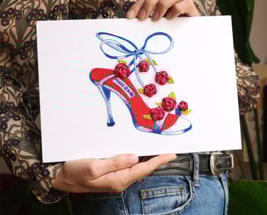 a woman holding a card with a drawing of a shoe