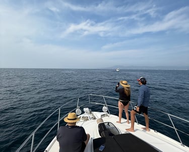 People relaxing on the bow of a luxury yacht while cruising on the deep blue ocean water.