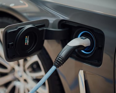 Um carro elétrico em uma estação de de recarga com o plug conectado.