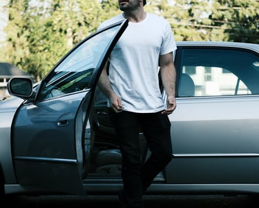 Commercial video production services: man standing in front of a car wearing a tie-dye shirt