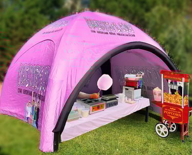 Pink inflatable event tent with cotton candy and popcorn machine rental for outdoor parties.