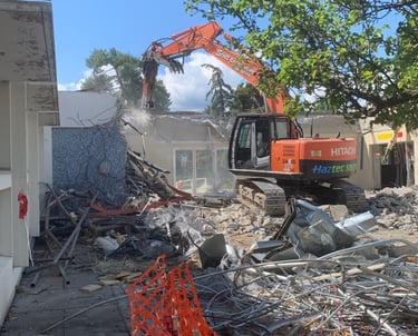 an excavator crushing a building made of concrete