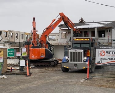 excavator loading a dump truck with debris