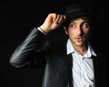 photo de portrait sur fond noir en studio, l'homme porte un chapeau