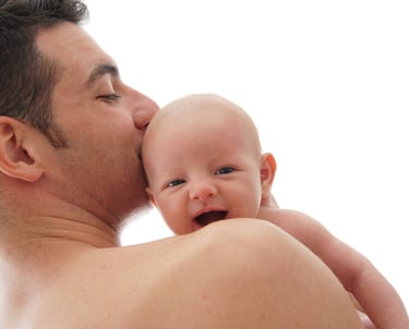 Bébé qui sourit avec la tête qui dépasse de l'épaule de son père lors d'une séance photo high-key