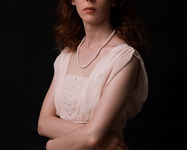 a woman in a white dress and pearls necklaces