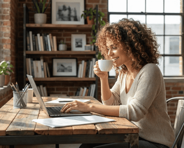 Mulher sorrindo tomando café em Curitiba enquanto trabalha