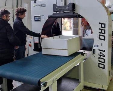a man standing in front of a machine that is cutting into a piece of paper