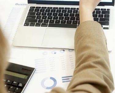 photographie d'une ordinateur portable et le bras d'une femme qui montre l'écran