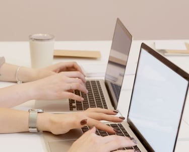photographie de deux femmes (mains) qui tapent sur le clavier de leur pc portable
