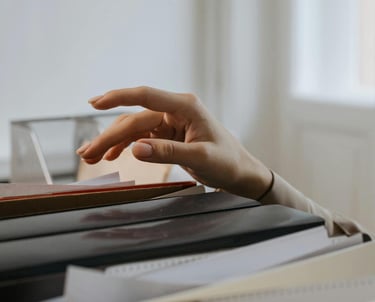 Photo d'une main au dessus de plusieurs dossiers administratifs