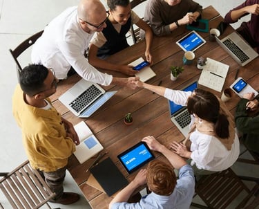 photo d'une équipe de personne autour d"une table qui travaille ensemble