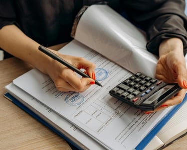 une photographie d'une femme qui tient un style et calculatrice sur un classeur administratif