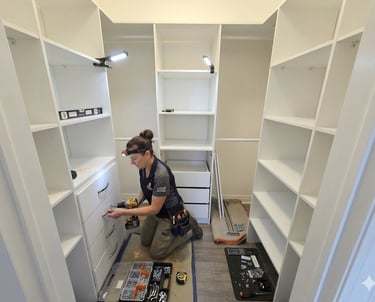 Professional closet installer assembling a custom white walk-in closet system with drawers