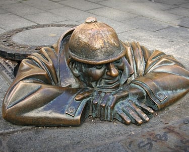Escultura de bronce de Čumil, el famoso “mirón” de Bratislava, saliendo de una alcantarilla