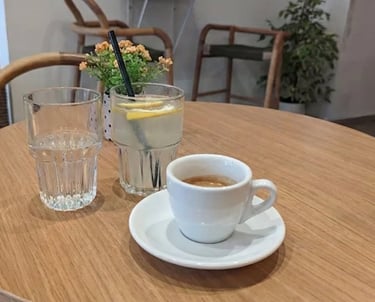Café espresso y limonada servidos en una mesa de madera en KeP’s caffetteria, una cafetería