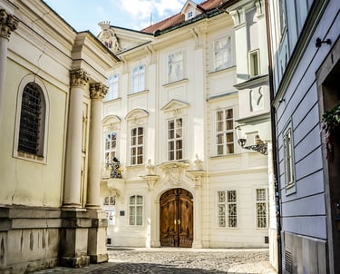 Fachada de un edificio barroco blanco en el centro histórico de Bratislava, al final de una calle ad