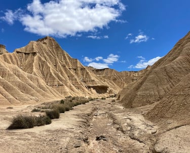 Paisaje en perspectiva desde el fondo de un barranco seco en Piskerra, rodeado de altas formaciones 