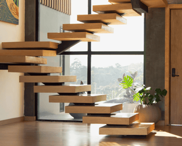 Escalera interior flotante de madera con estructura metálica y fondo acristalado.