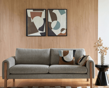 Canapé gris moderne avec tableaux abstraits et mur bois - nettoyage mobilier contemporain Paris