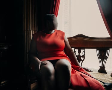 British escort sitting on a char, wearing an orange dress, Luxembourg