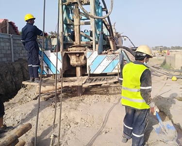 a man in a yeellow vest drilling a well
