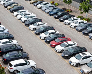 A technician setting up equipment beside a busy road to measure vehicle queues during rush hour.
