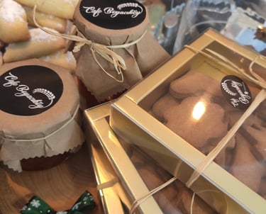 üzerinde cafe boyacıköy logosu bulunan zencefilli kurabiye dolusu kutular var ev yapımı reçel kavanozları