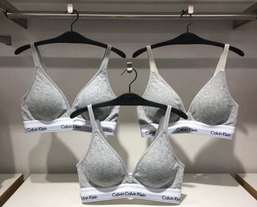 An elegant collection of popular branded cosmetics with sleek packaging on a marble countertop.