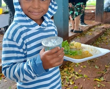 Um menino segurando seu prato de comida