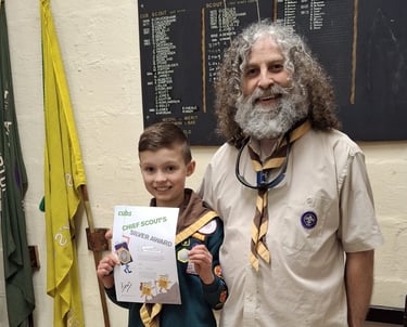 A cub from the 25th Allerton receives his award from a leader. 