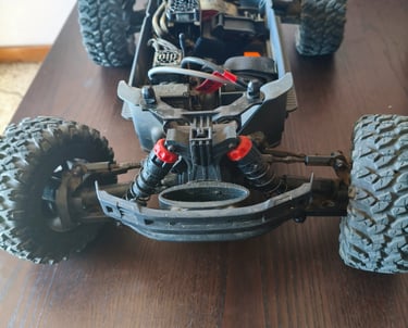 Review de ARRMA Big Rock 3S BLX detalhando os braços de suspensão e o para-choques frontal interno.