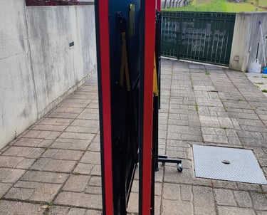 Mesa de ténis TOPGIM Training dobrada de lado com rodas visíveis no exterior