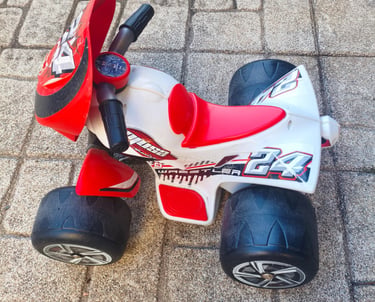 Vista lateral da Moto 4 elétrica Injusa Wrestler 6V com detalhes em vermelho, branco e preto