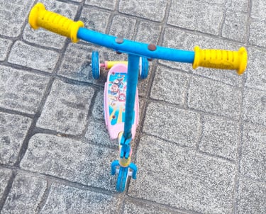 Vista de cima da trotinete Paw Patrol Smobe com guiador amarelo e azul e plataforma rosa com persona