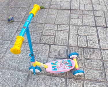 Trotinete 3 rodas Paw Patrol Smobe em azul e rosa em uso exterior com calçada portuguesa ao fundo