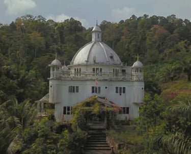 Majestic white domed palace surrounded by a lush tropical rainforest landscape.