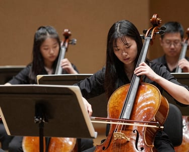 Students celebrating on a sports field with medals and banners under a clear blue sky.