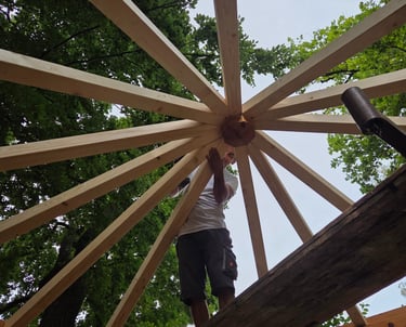 Handwerker bei der Montage der sternförmigen Dachkonstruktion eines Holzpavillons von Holztechnik Volk am Ammersee