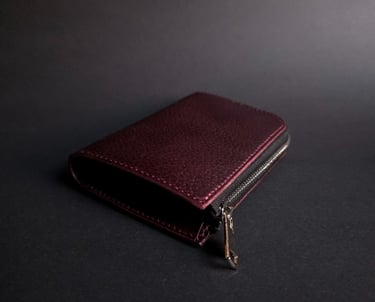 Handmade vegetable tanned leather wallet in burgundy. L-shape wallet in black background.