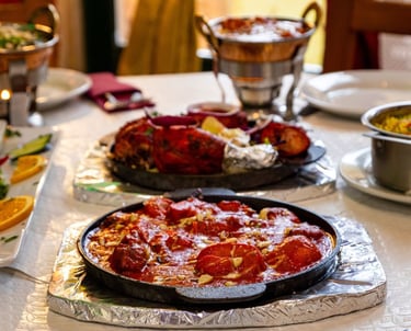 Sizzling authentic Indian butter chicken and tandoori chicken served on hot plates at a restaurant table.
