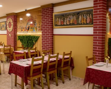 Elegant Chinese restaurant dining room with red brick pillars and traditional cultural artwork.