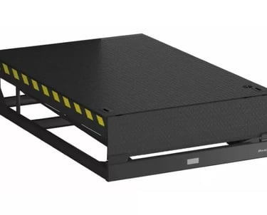 Industrial black mechanical dock leveler for loading bay with yellow safety stripes.