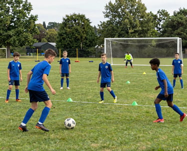 Young football players celebrating a goal on a green pitch under a clear blue sky.