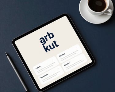 A top-down view of a designer's workspace featuring a tablet with a branding mockup, a sleek digital pen, and a cup of espresso. The color palette is dark navy and off-white. Professional North American studio setting.